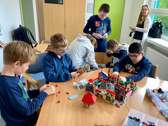 Schüler bauen mit Lego am Tisch